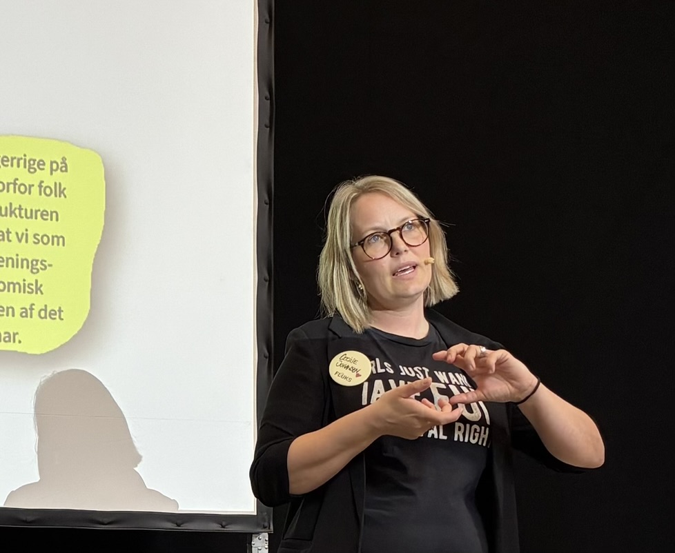 Cecilie Engelhardt holder oplæg med mikrofon og gestikulerer.
